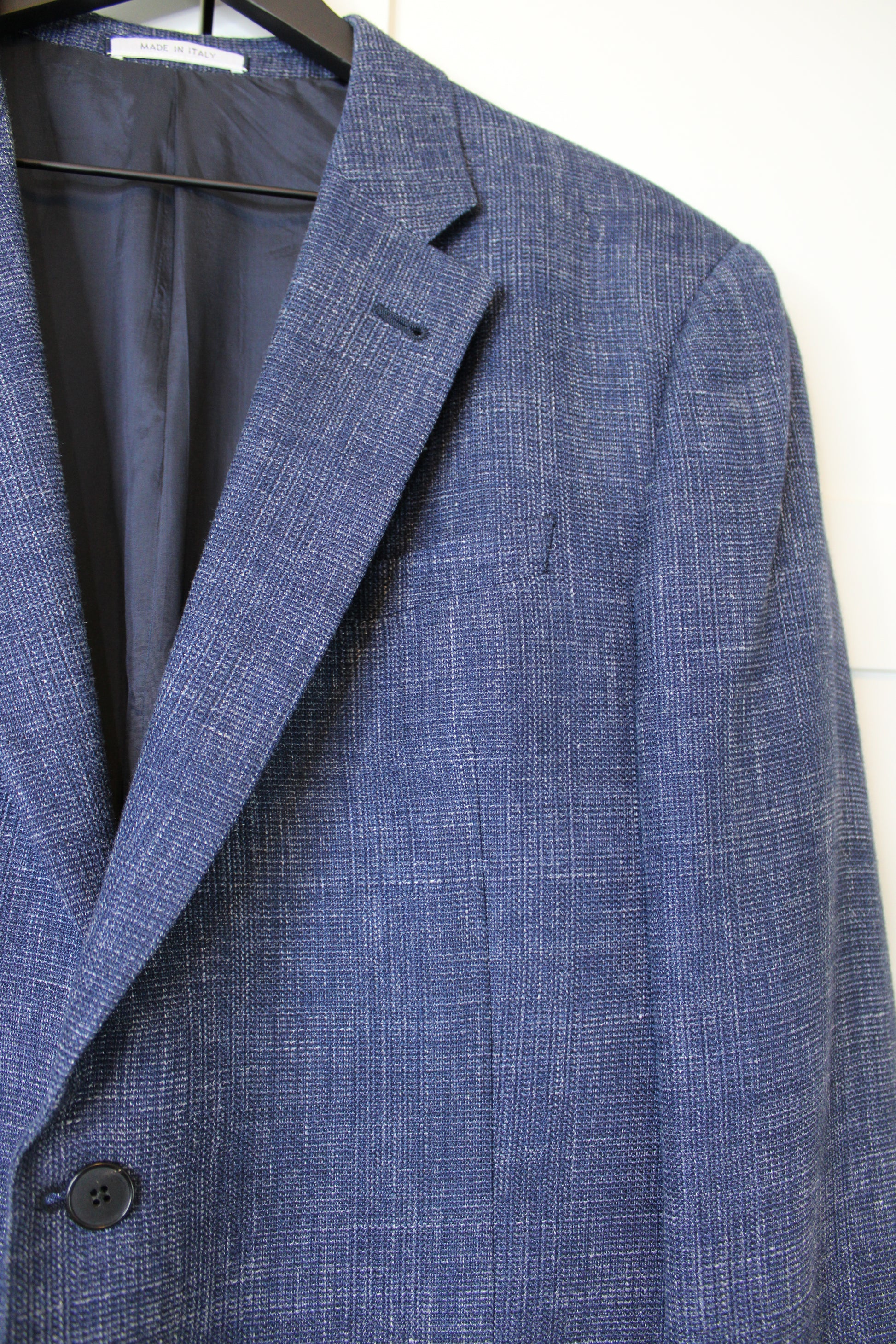 Close-up of a blue checkered suit jacket on a white background