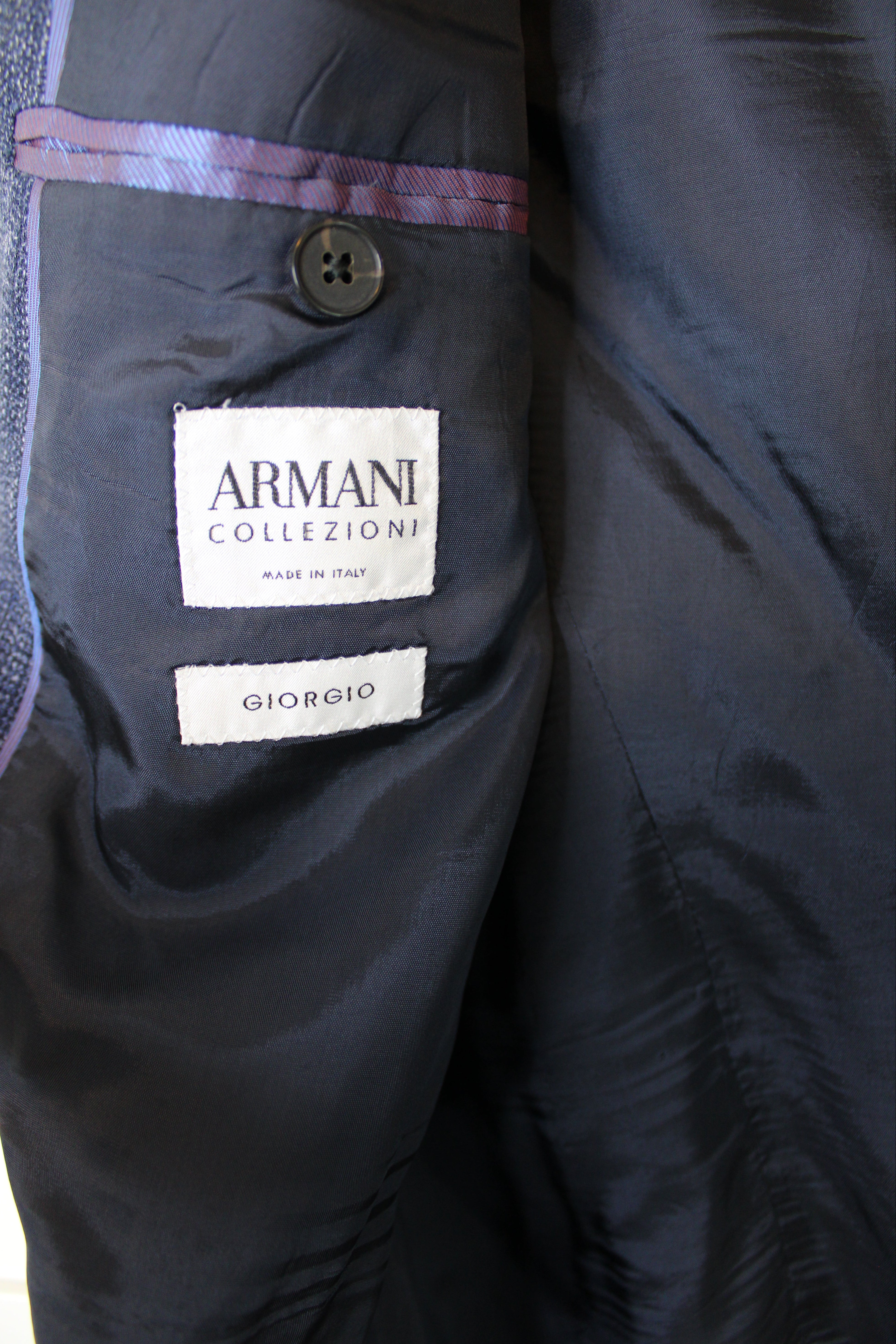 Close-up of a dark jacket with Armani Collezioni label