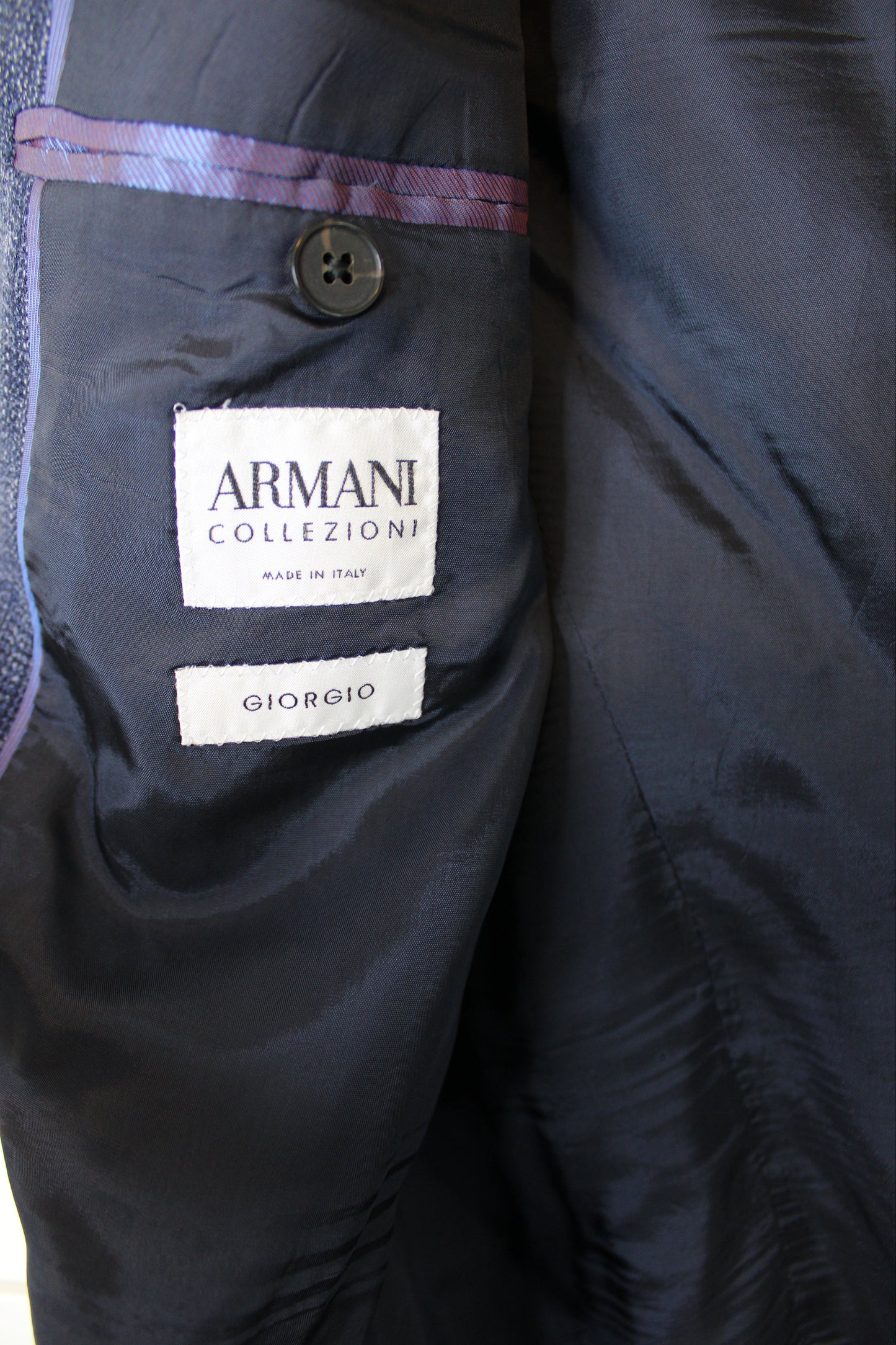 Close-up of a dark jacket with Armani Collezioni label